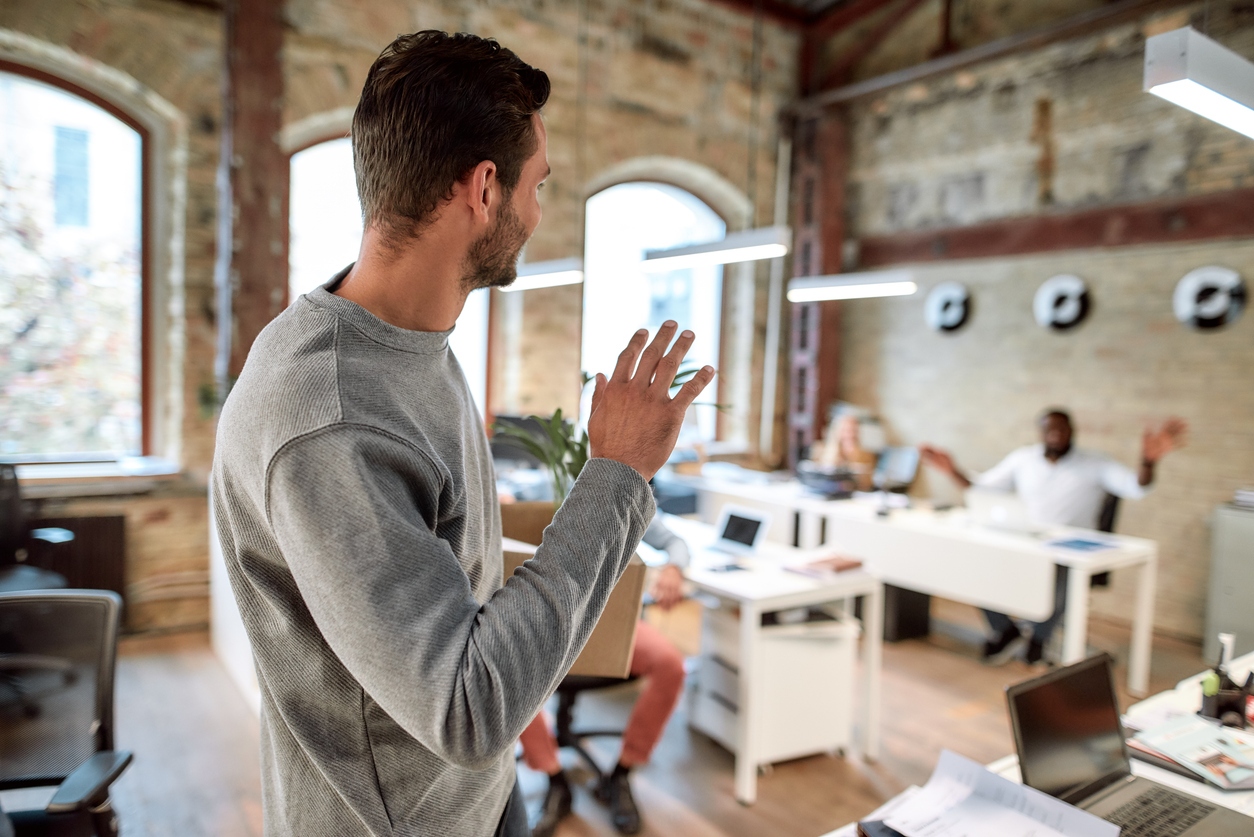 Man leaving office waving