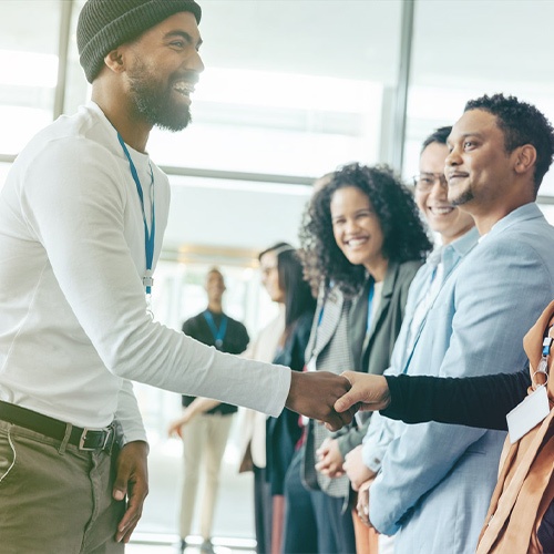 man shaking hands with group