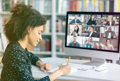 woman taking notes on video conference