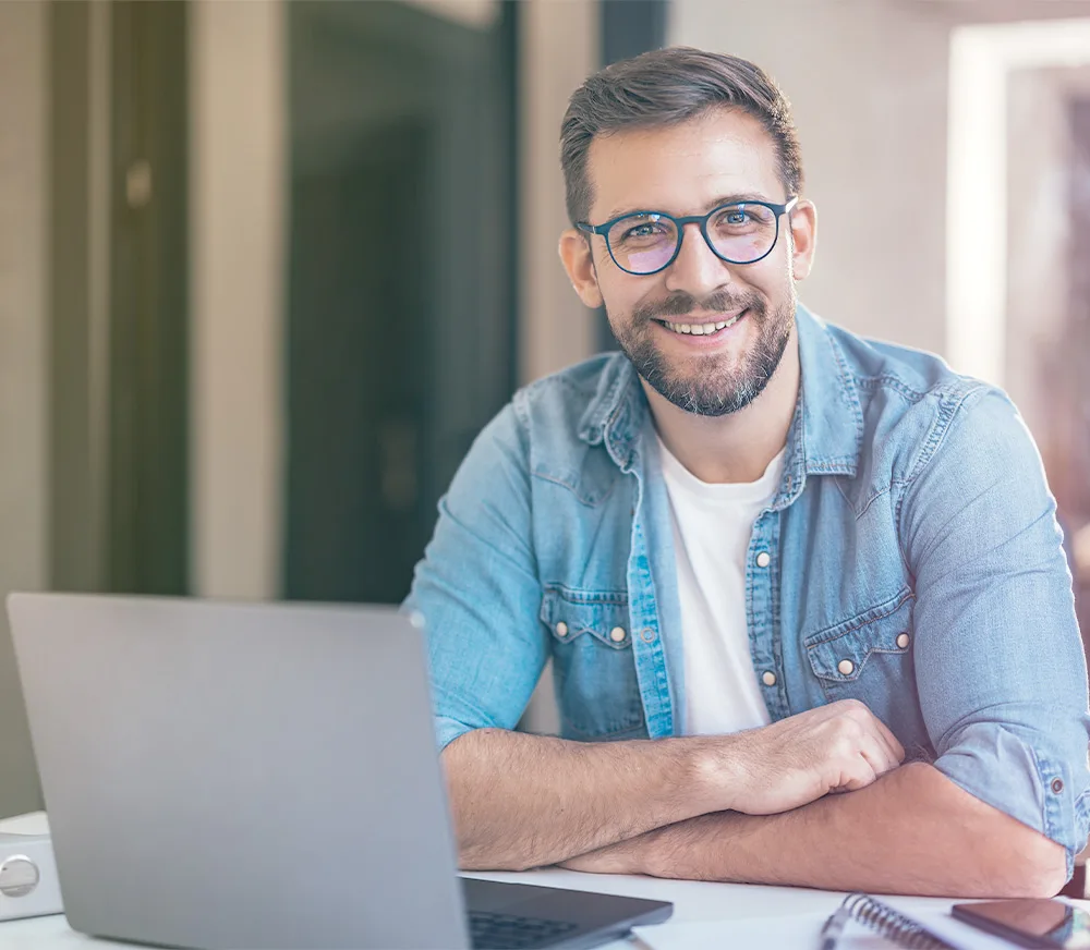 man smiling at laptop